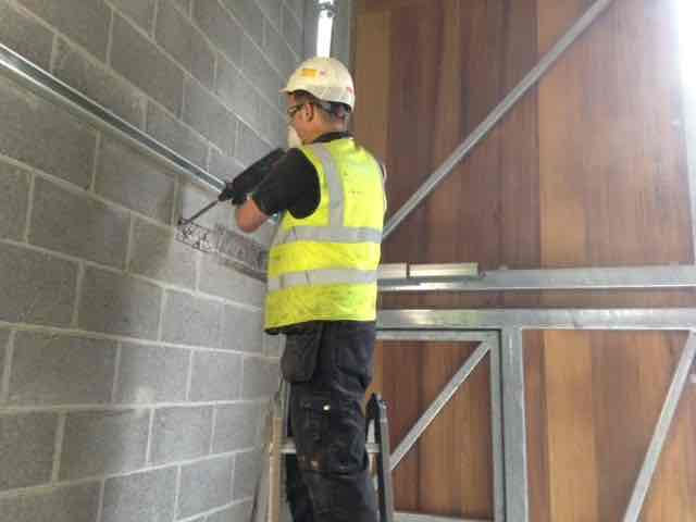 Industrial Door Repairs - Engineer Repairing Door